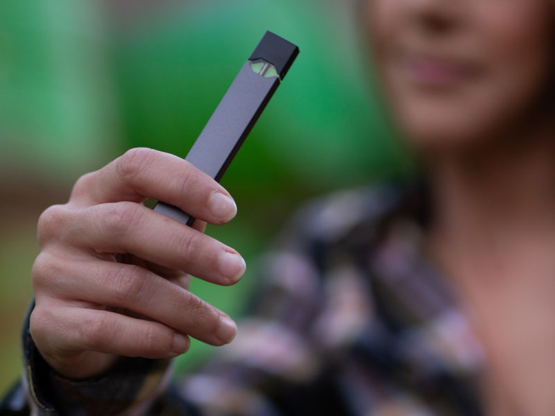 female hand holding a vaping device