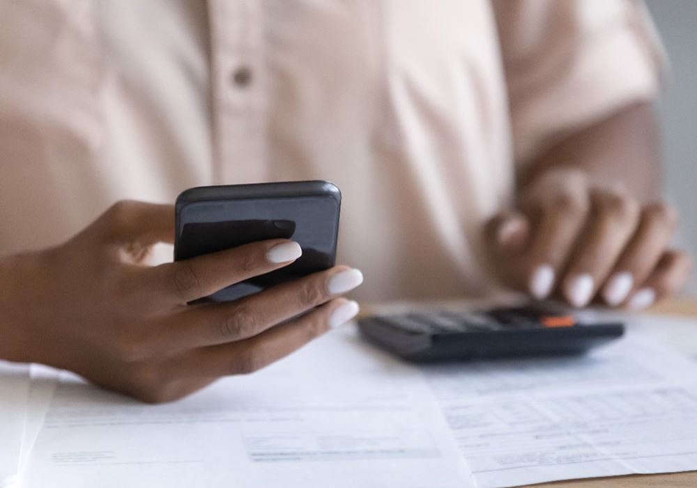 Hands holding a phone and calculator