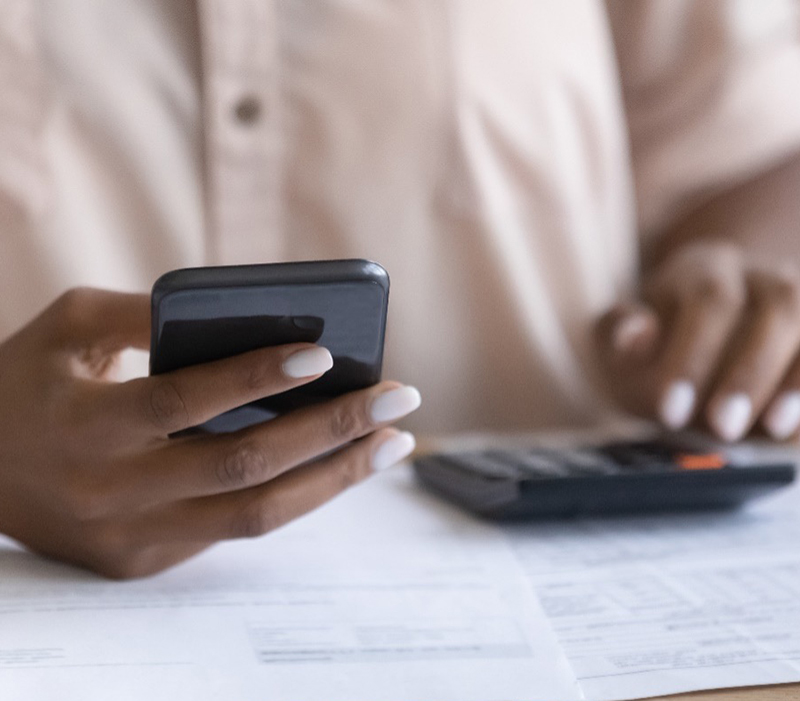 Hands holding a phone and calculator