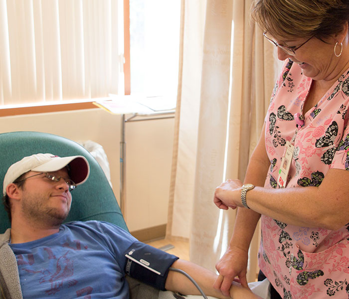 Oncology nurse treating young adult with cancer