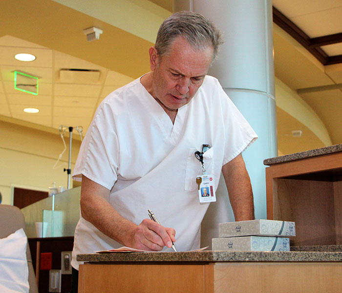 An oncology nurse reviewing a patient file